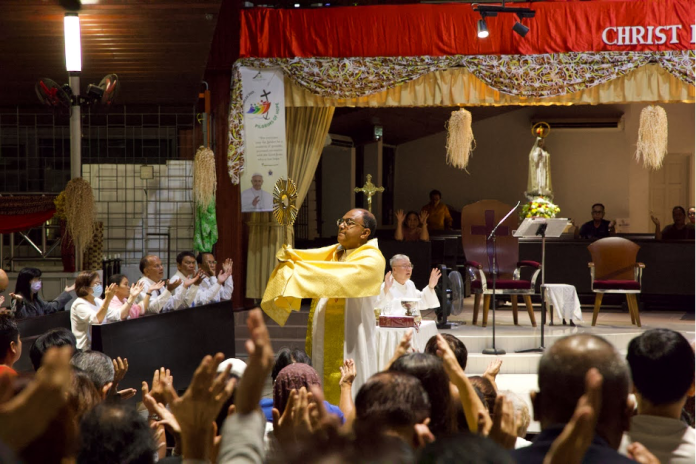 Fr Thomas Bobby Emprayil VC memberkati jemaat semasa adorasi Ekaristi. Berlutut di belakangnya adalah Fr Nicholas Ng, 15 Mei 2025, Katedral St Joseph. (Gambar: Stephanie Chua)