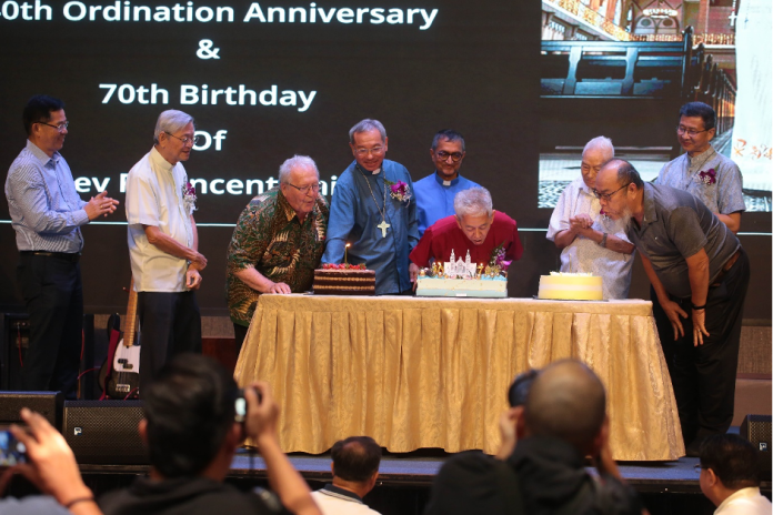 Fr Vincent Chin sharing the stage with birthday celebrants, visiting Austrian priest Fr Sepp and Fr James Ting from Sarikei.